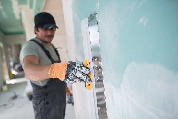 istock Construction worker preparing a wall for painting during home renovation 2235318594