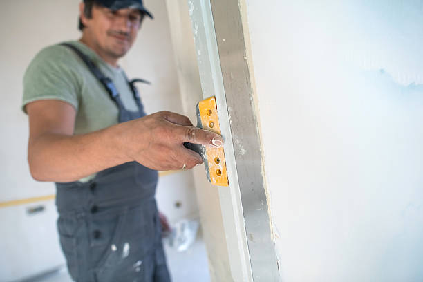 istock Construction worker preparing a wall for painting during home renovation 2235318617