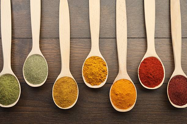 istock Different aromatic spices in spoons on wooden table, flat lay 2235321474