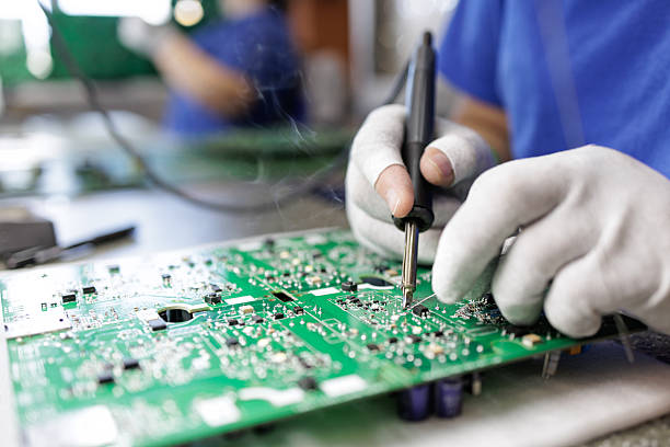 istock Gloved technician hand soldering components on printed circuit board in factory 2235325131