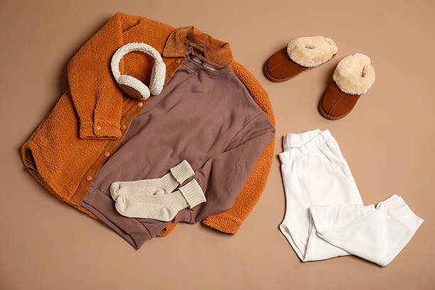 Stylish clothes, boots and accessories on beige background, flat lay