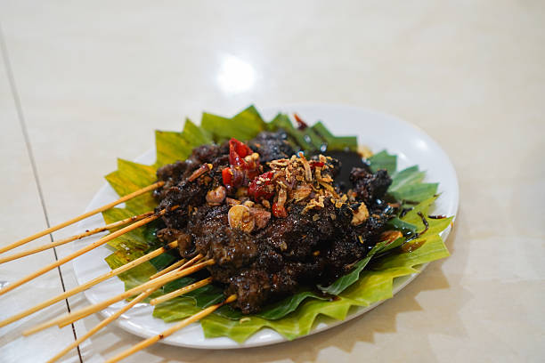Traditional Indonesian sate maranggi, grilled beef satay skewers served on banana leaf with spices.