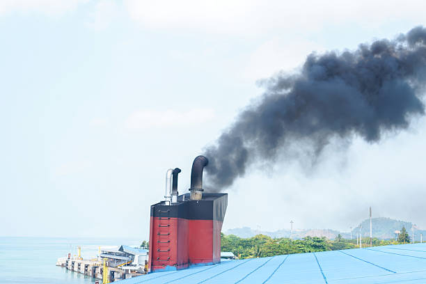 Cruise ship smokestacks standing tall on the upper deck, releasing exhaust into a clear blue sky, symbolizing travel, vacation, and ocean transportation from Miami, Florida
