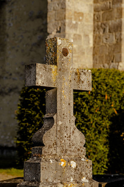 White christian stone cross in a cemetery in spring