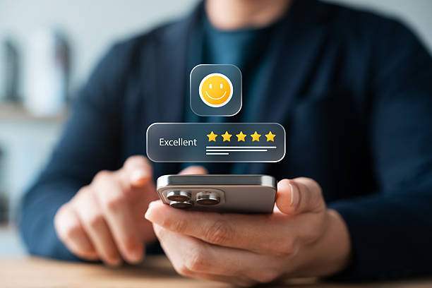 istock Satisfaction reviews, Customers give 5-star reviews, indicating excellent user experience and high satisfaction. Man holding smartphone with smiley face icon, user feedback, digital reputation. 2235329964