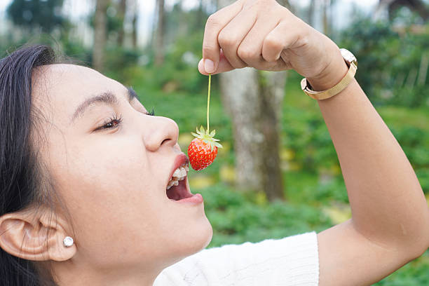 Woman eating strawberry close up