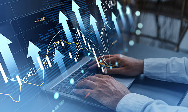 istock Businessman analyzing stock market data on laptop with upward arrows and graphs representing financial growth and investment concept on blue background. 2235333726