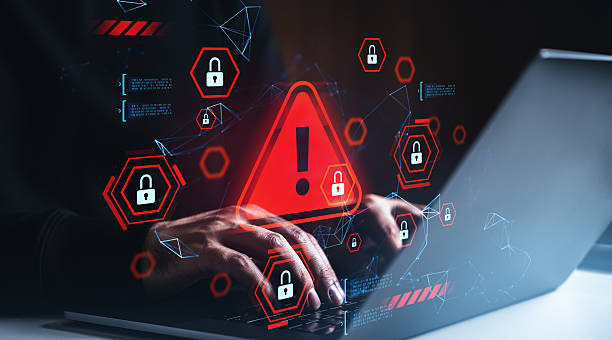 istock Cybersecurity breach warning concept with hands on keyboard, red alert triangle and digital padlocks on dark background with glowing tech graphics. 2235335137