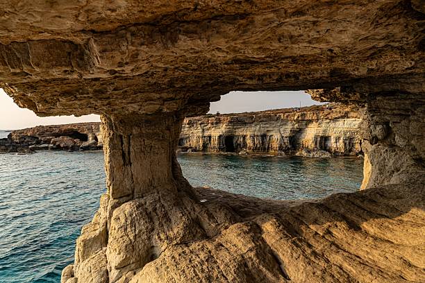 istock Scenic coastal view through a rock archway. 2235340010