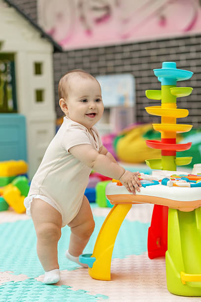 istock Happy baby playing with colorful activity toy. Early development 2235345004