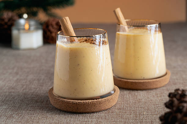 istock Two glasses of a eggnog with cinnamon sticks in them 2235345057