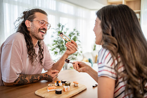 istock Happy couple sharing sushi in their modern apartment 2235349827