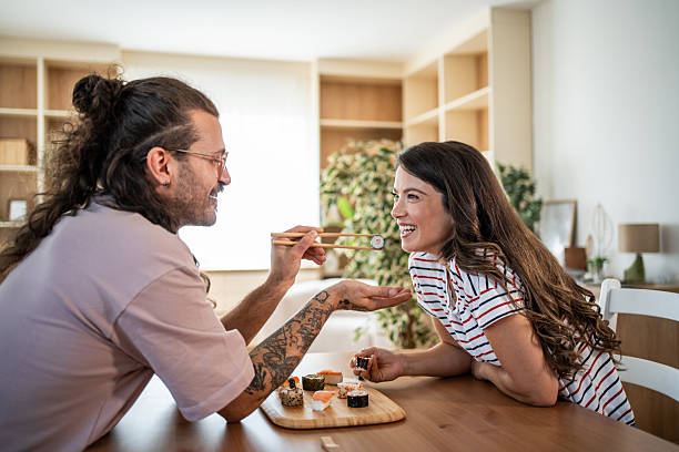 Young couple sharing sushi in their modern apartment