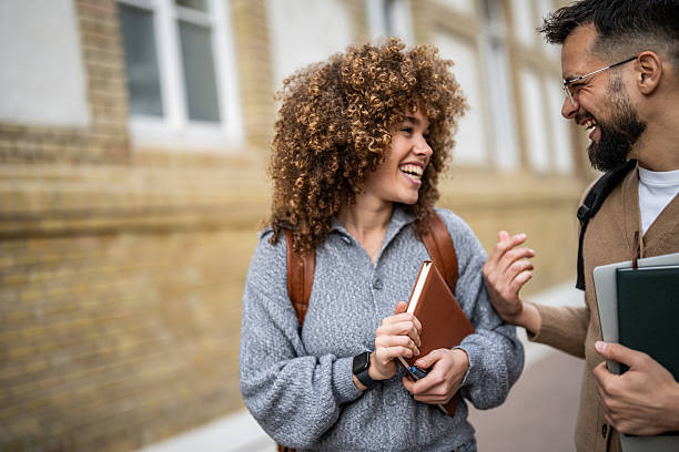 istock Two smiling students walking and talking outside of school 2235351165