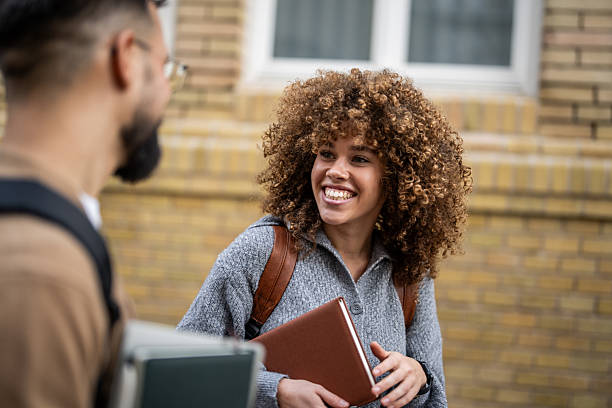 istock Two smiling students talking outside of school building 2235351184