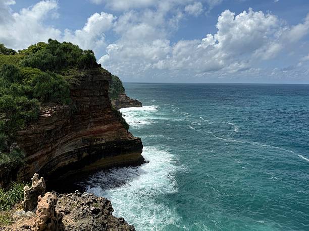 istock Majestic Coastal Cliff with Waves Crashing Against Rock Layers 2235352069