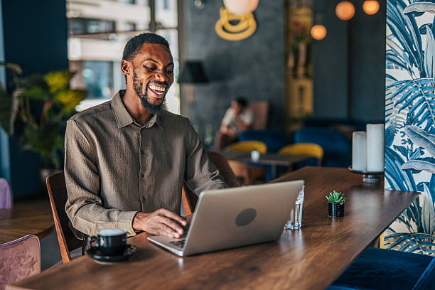 istock Young businessman working on laptop in a modern cafe 2235355567