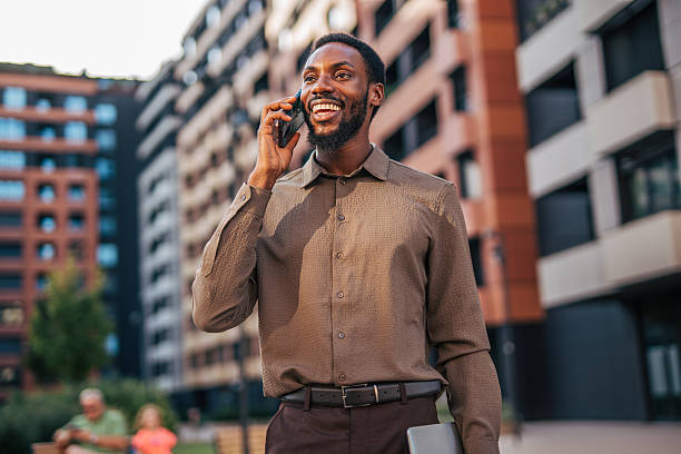 istock Smiling businessman talking on phone in city 2235355606