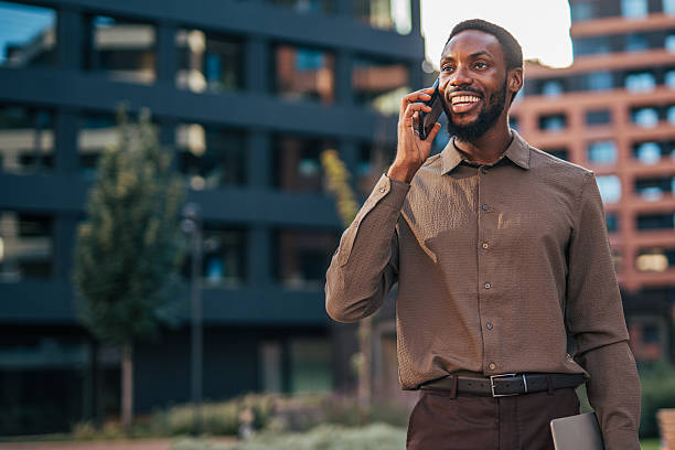 istock Smiling businessman talking on phone outside office building 2235355796