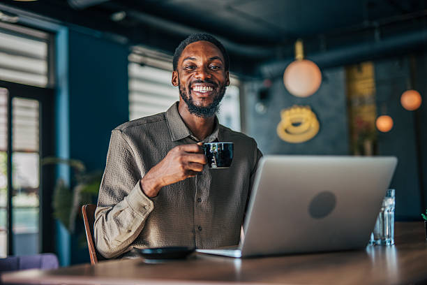 istock Young businessman drinking coffee and working on laptop in a cafe 2235355978