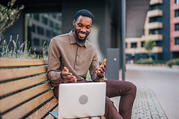 istock Businessman making video call sitting on bench outside office 2235357080