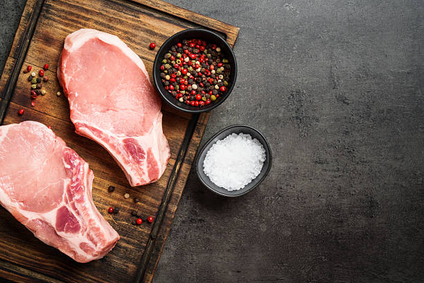 istock Raw pork meat steaks on cutting board. 2235357401