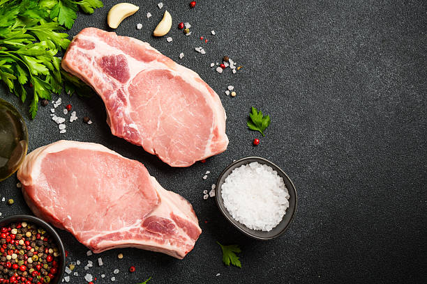 istock Pork meat steaks on cutting board. 2235357508