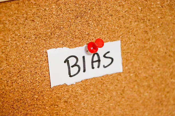 Handwritten note reading BIAS pinned to a corkboard, highlighting themes of judgment, prejudice, or preference in various contexts. Ideal for discussions on social issues.
