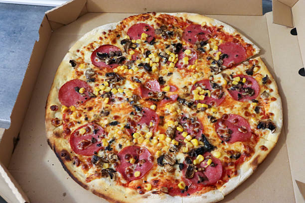 istock A delicious pizza featuring pepperoni, corn, black olives, and mushrooms, presented in an open pizza box. Ideal for food and dining themes. 2235358865
