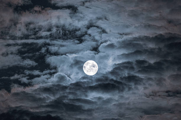 istock Dramatic clouds in the moonlight. Full moon in the night sky 2235360398