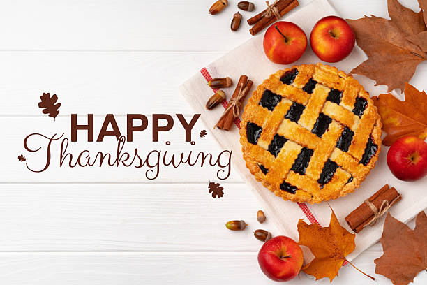 istock Thanksgiving celebration with pie, apples, and autumn decorations on a wooden table 2235361837