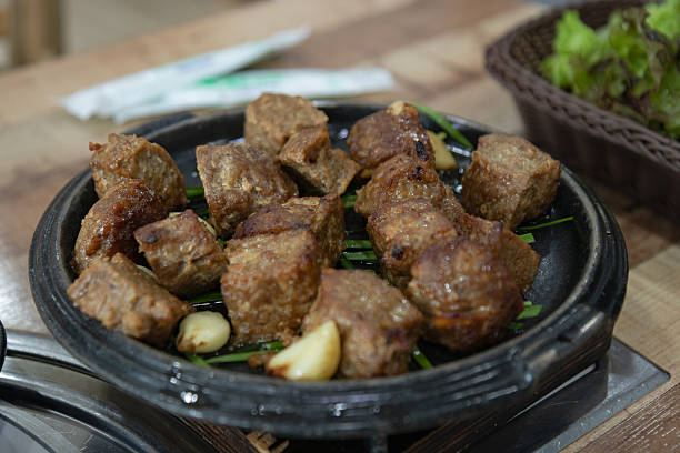 This collection of photographs showcases the delicious local cuisine of Danyang, a city in South Korea known for its garlic specialties. The images feature tteokgalbi (grilled short rib patties) and soondae-guk (sausage soup) served with various traditional side dishes. This visual is perfect for projects on Korean food, travel, and authentic dining experiences.