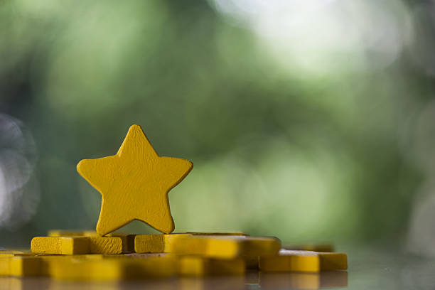 Wood yellow star on a nature backdrop. Banner with copy space. Rating Satisfaction concept