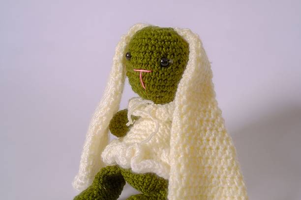 istock Close-up image shows a green crocheted bunny doll. 2235366332