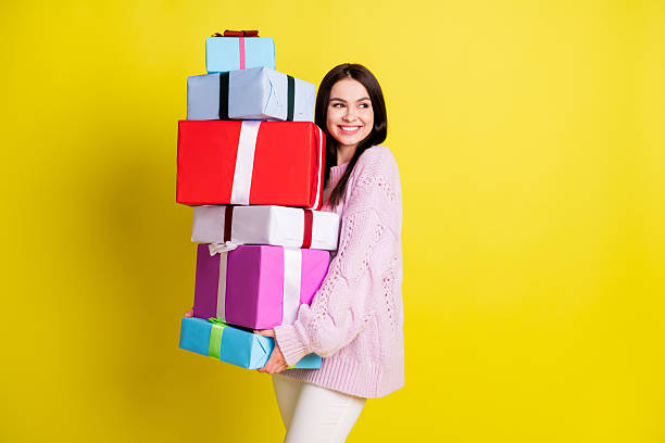 istock Funky millennial lady hold gifts look empty space wear rose pullover pants isolated on vivid yellow color background 2235370024