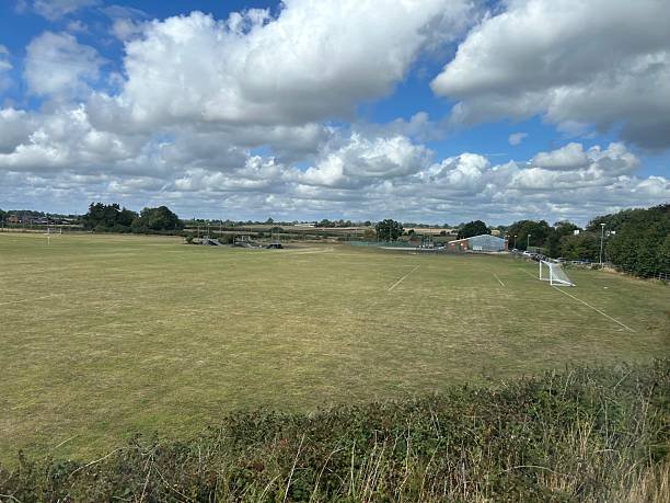 istock Open Green Field with Soccer Goal Under a Partly Cloudy Sky 2235370852
