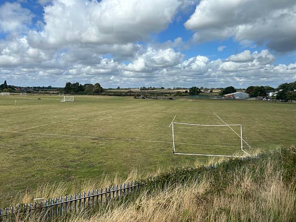 istock Open Green Field with Soccer Goal Under a Partly Cloudy Sky 2235370854