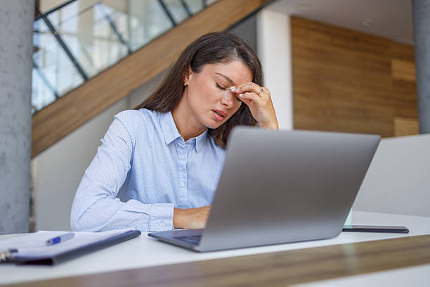 istock Stressed businesswoman suffering from headache while working on laptop 2235371273