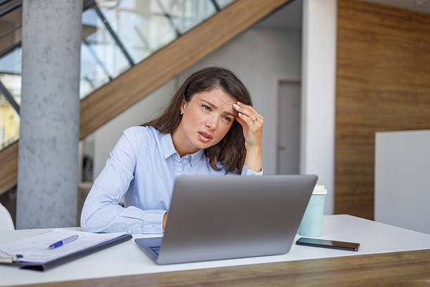 istock Stressed businesswoman having headache while working on laptop in office 2235371306