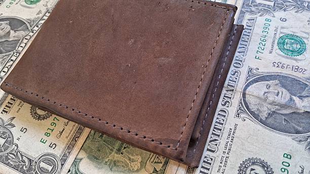 istock Leather wallet and us dollar bills 2235372795