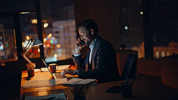 istock Professional employee smartphone call at evening company workspace. Man talking 2235373009