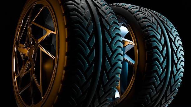 istock Three modern car wheels with alloy rims standing together in dark light 2235374125