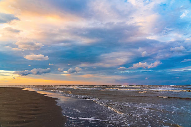 Beach at sunset with beautiful clouds and slightly stormy sea