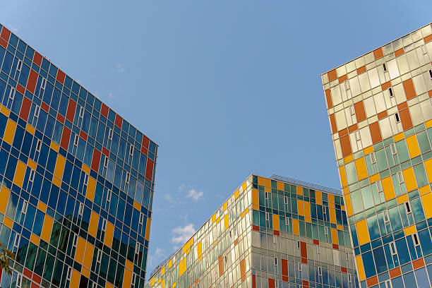 istock Three high-rise buildings with colorful panel facades set against a clear blue sky. 2235387432