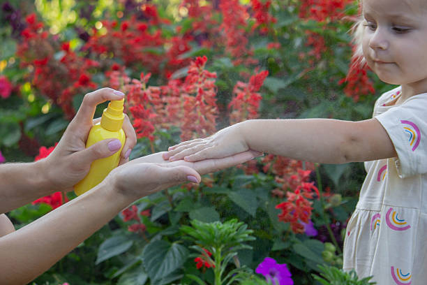 istock Father applying insect repellent spray to child's hand outdoors. Selective focus 2235388830