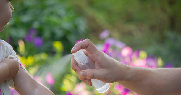 istock Father applying insect repellent spray to child's hand outdoors. Selective focus 2235388839