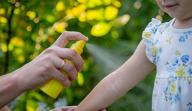 istock Father applying insect repellent spray to child's hand outdoors. Selective focus 2235388846