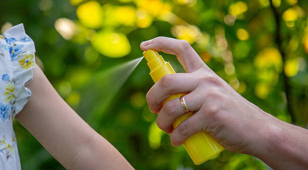 istock Father applying insect repellent spray to child's hand outdoors. Selective focus 2235388855