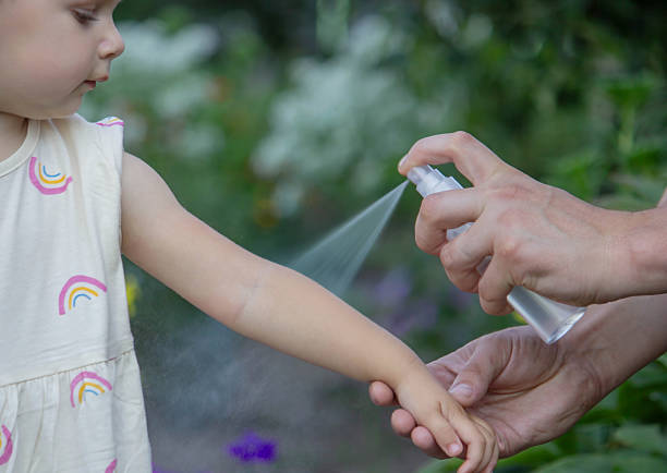 istock Mother applying insect repellent spray on childs arm outdoors. Selective focus 2235388859