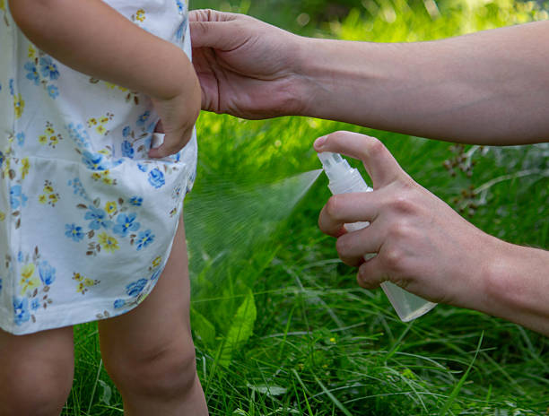 istock Father applying insect repellent spray to child's hand outdoors. Selective focus 2235388866